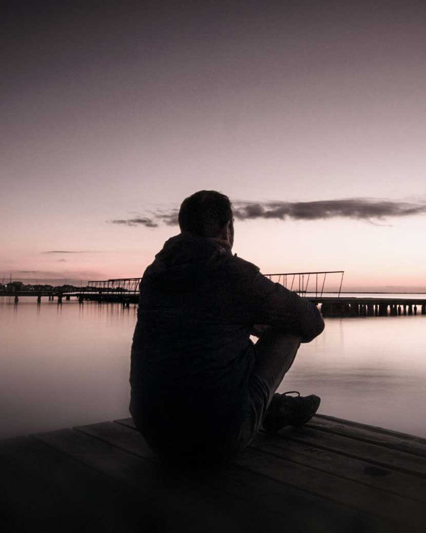 Nach der Psychotherapie bei Asli Demirel, Heilpraktikerin für Psychotherapie, ein nachdenklicher Mann am Wasser bei Morgendämmerung, ein neuer Tag beginnt mit neuen Hoffnungen und Anfängen.